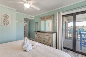 A bedroom with a bed, a dresser, a ceiling fan, a sliding glass door to an outdoor area with chairs. - Steps to Sand! Pool-view Retreat in Myrtle Beach (Myrtle Beach)