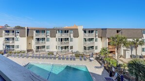 A hotel with multiple balconies, a swimming pool, and sun loungers. - Steps to Sand! Pool-view Retreat in Myrtle Beach (Myrtle Beach)