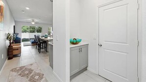 Une cuisine moderne avec des meubles blancs, un plan de travail et un saladier décoratif.