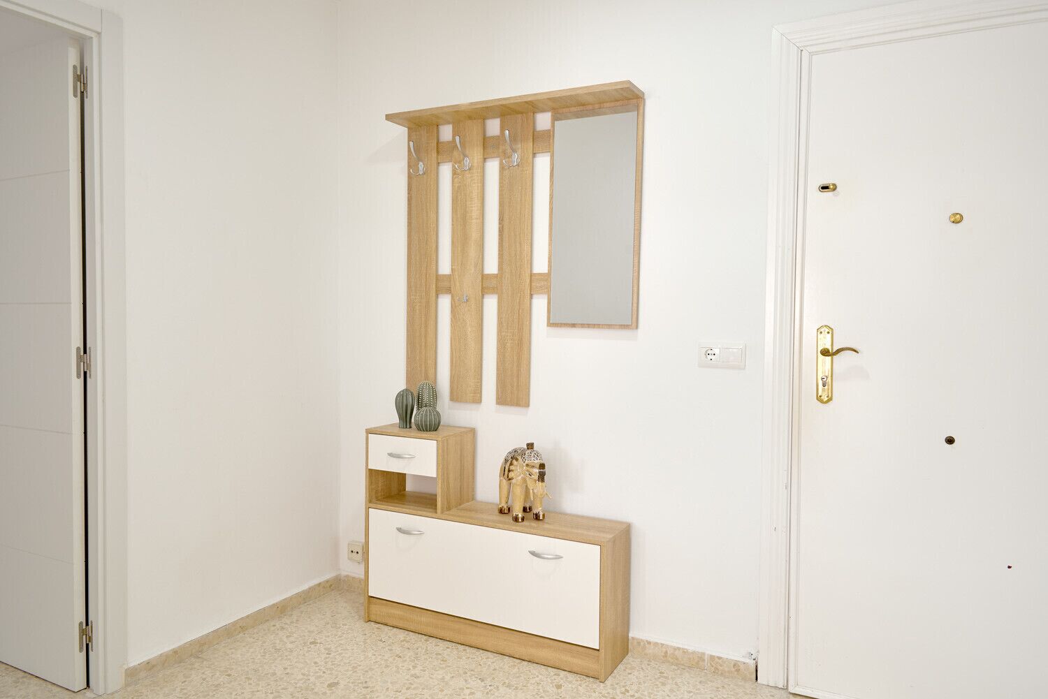 A minimalist bedroom with a wooden vanity, a mirror, and a door with a brass handle.