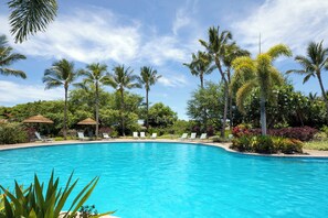 A clear blue pool surrounded by palm trees and lounge chairs. - Bikes,Beach Gear & Exclusive Mauna Lani Beach Club Access 3BR Kulalani Condo (Kamuela)