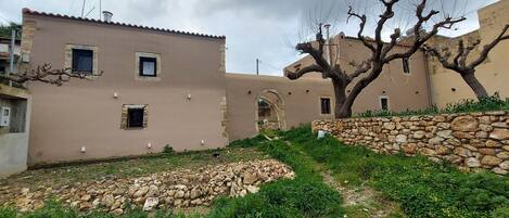 Ein traditionelles Gebäude mit einer Steinwand und einem Baum im Innenhof.