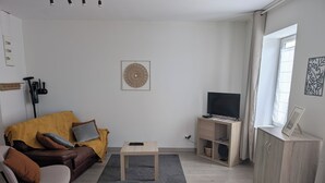 A modern living room with a sofa, coffee table, and TV stand.