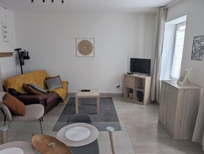A modern living room with a sofa, coffee table, and TV stand.