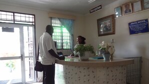 A reception area with a reception desk, a sign labeled "Reception," and a "POLITE NOTICE" sign on the wall. - White Castle Hotel Mikindani (Mombasa)