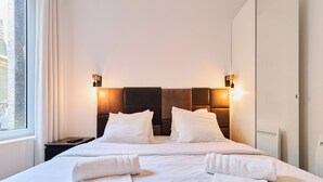 A hotel room with a large bed, two bedside tables, and a window. - La Suite Urbaine - Place d'Erlon - Bulle de Calme (Reims)