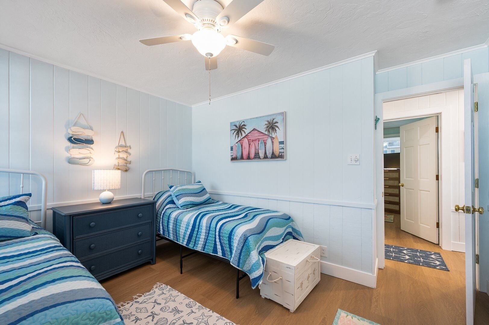 A bedroom with a bed, nightstand, dresser, and a ceiling fan.