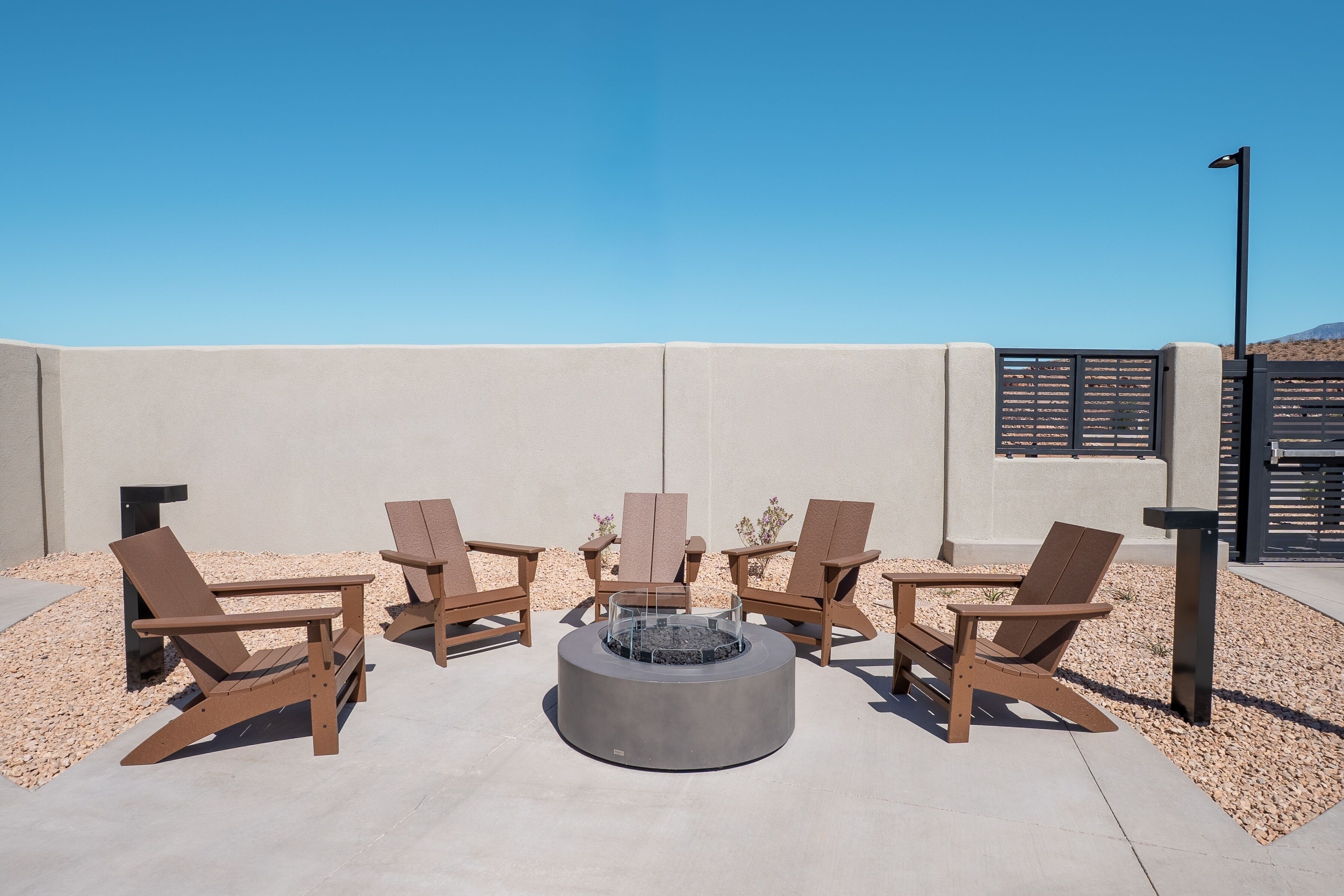 Une terrasse sur le toit avec quatre fauteuils Adirondack et un foyer circulaire.