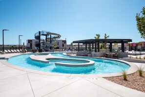 A swimming pool with a unique spiral design, lounge chairs, and a covered seating area. - Isle Be Back 6 Bedroom Townhouse (Washington)