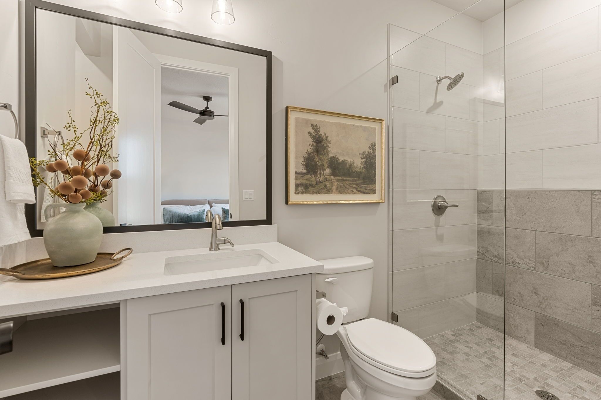 Une salle de bain moderne avec un lavabo blanc, des toilettes et une douche à parois de verre.