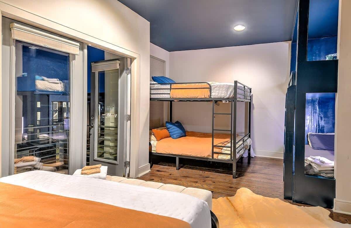 Una habitación con una cama litera, un armario grande y una cama con una colcha.