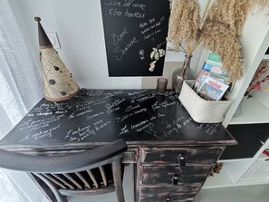 A blackboard with handwritten notes, a decorative cone, and a vase with dried plants. - Coco on peaceful 37m2 between lake and mountains (Dingy-Saint-Clair)