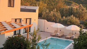 Ein modernes Gebäude mit Schwimmbad und Liegestühlen.