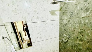 A bathroom with a sink, mirror, toilet, and shower. - Rathi Residency I Ambala (Ambala)
