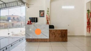 A reception area with a marble counter, a television, and a view of the outside. - Rathi Residency I Ambala (Ambala)