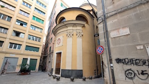 Una estrecha calle con un edificio que tiene una entrada circular y un letrero que dice 'VICO SAN PANCRAZIO'.