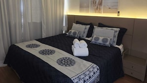 A hotel room with a large bed, a nightstand, a lamp, and a painting on the wall. - The Palace Moema 501 (São Paulo)