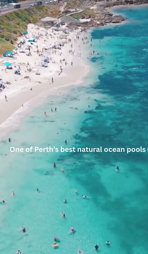 An aerial view of a beach with clear turquoise waters and a sandy shore. - Mettams Pool Residence | Luxe 4BR Ocean Views | Welcome Drinks & Nibbles (North Beach)
