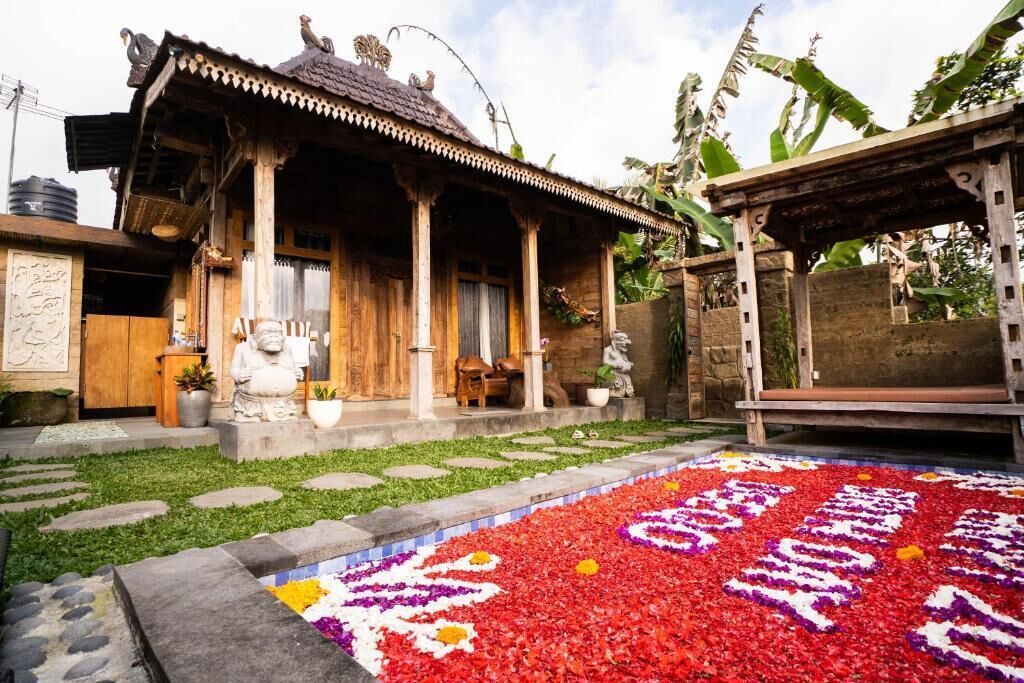 Ein traditionelles Holzhaus mit Veranda, einem Steinweg und einem blumengeschmückten Bereich davor.