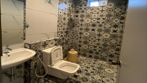 A bathroom with a sink, toilet, and shower area. - The K Inn Wavefront (Tirukalukundram)