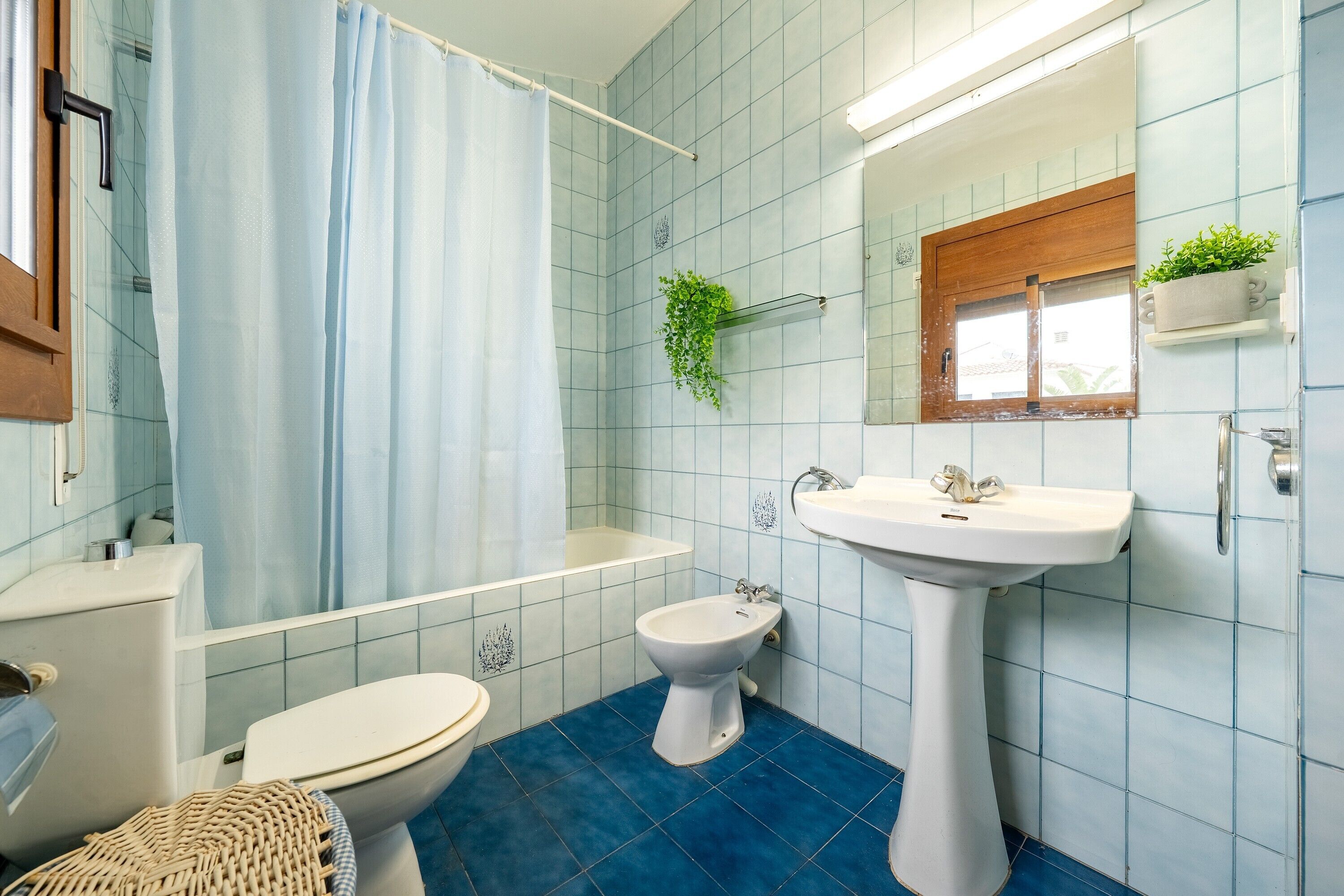 Une salle de bain équipée d’une baignoire, de toilettes, d’un bidet et d’un lavabo.