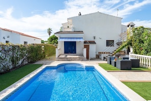 A swimming pool with a white building in the background.