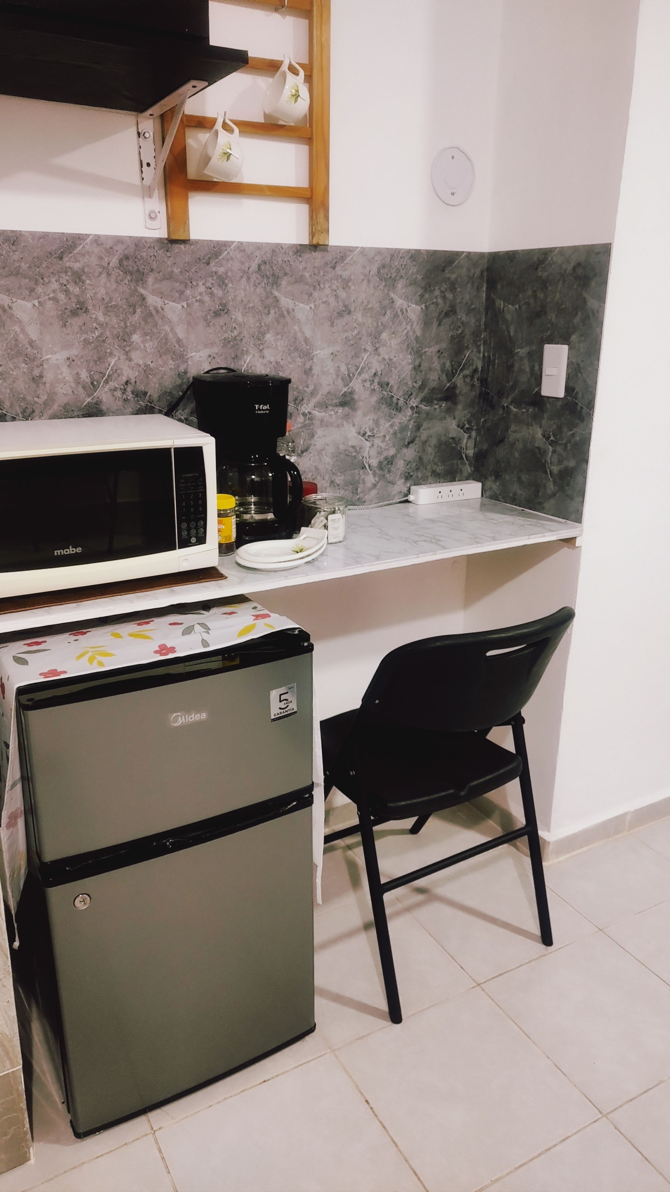 A compact kitchenette with a microwave, coffee maker, and a small refrigerator.