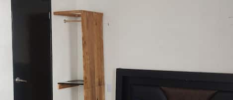 Une chambre à coucher comprenant un lit, une armoire et un appareil de climatisation.