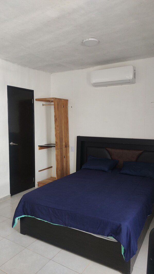 Une chambre à coucher comprenant un lit, une armoire et un appareil de climatisation.