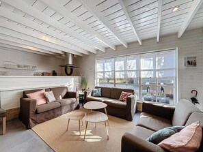 Un salón amplio con dos sofás, una mesa de centro y un ventanal que ofrece vistas al exterior.