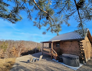 A wooden cabin with a porch, a hot tub, and a gravel driveway. - NEW Cabin in Hocking Hills - The Overlook (Logan)
