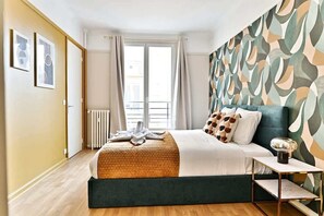 A bedroom with a bed, bedside table, and a window with curtains. - Calm and light in the heart of Neuilly (Neuilly-sur-Seine)