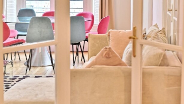 A room with a dining area, a sofa, and a view of the outside. - Superb 2-bedroom apartment in Neuilly-sur-Seine (Neuilly-sur-Seine)