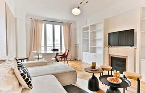 A modern living room with a sofa, a dining table, and a fireplace. - Neuilly-sur-Seine, family cocoon (Neuilly-sur-Seine)