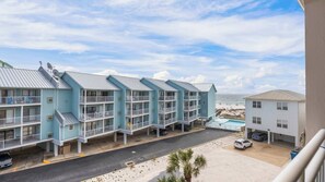 Ein Strandhotel mit mehrstöckigen Gebäuden, Balkonen und einem Schwimmbad.