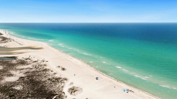 A beach with clear turquoise waters, sandy shore, and sparse vegetation. - Mystic Hideaway 7 BR + Private Pool & Pet Friendly (Inlet Beach)