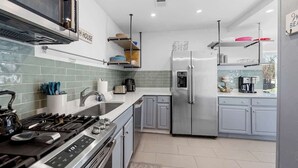 Een moderne keuken met roestvrijstalen apparatuur, een gasfornuis en een koelkast.