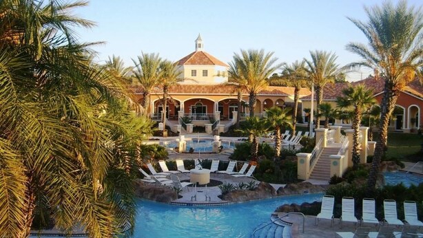 A resort with a swimming pool, palm trees, and a building with a dome roof. - Near Disney Family Fun with Resort pools, Lazy River, Arcade, Restaurants (Davenport)