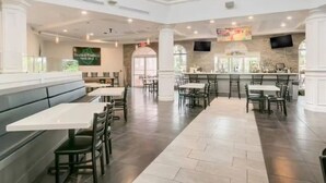 A spacious restaurant with high ceilings, a bar area, and a seating arrangement that includes booths and tables. - Near Disney Family Fun with Resort pools, Lazy River, Arcade, Restaurants (Davenport)
