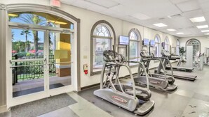 A gym with treadmills, exercise equipment, and large windows. - Near Disney Family Fun with Resort pools, Lazy River, Arcade, Restaurants (Davenport)