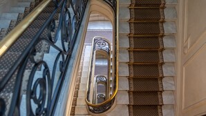 Eine Treppe mit aufwendiger Metallreling und gemusterten Stufen.