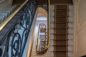 A staircase with ornate metal railings and patterned steps. - Arc de Triomphe - 2 personnes - Bail Mobilité (Paris)