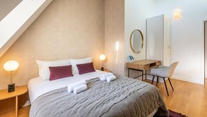 Un dormitorio moderno con cama, mesitas de noche, escritorio y silla.