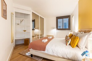 Un dormitorio con cama, armario, ventana y radiador.