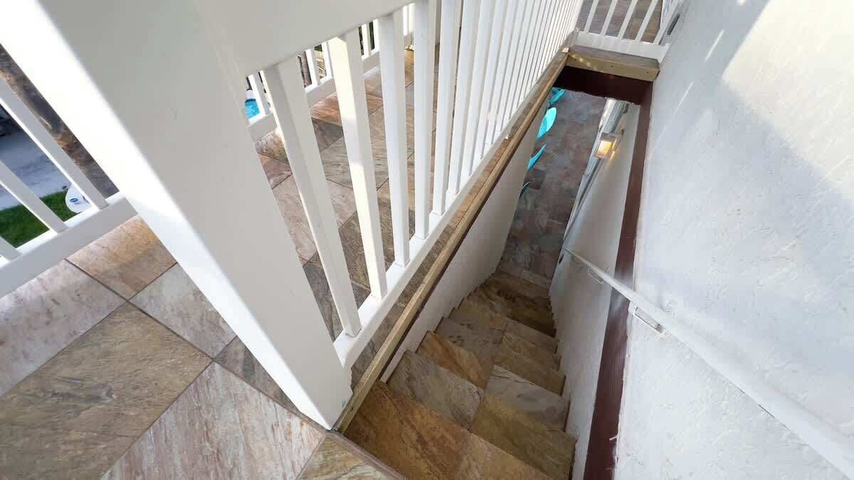 A staircase with white railings and stone steps.