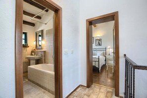 A bathroom with a bathtub, sink, and mirror.