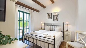 A bedroom with a bed, bedside tables, a chair, and a window with curtains. - Villa Silene - Authentic villa near Višnjan (Barat)