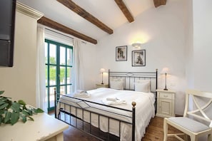 A bedroom with a bed, bedside tables, a chair, and a window with curtains.