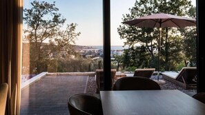 Une terrasse avec une table et des chaises, un parasol et une vue sur le paysage urbain.