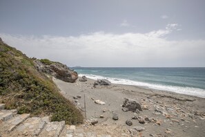 A coastal beach with rocky terrain and a clear view of the ocean. - Entire Cottage in Kerames, Crete – 250 m from the Beach (Agiou Vasileiou)